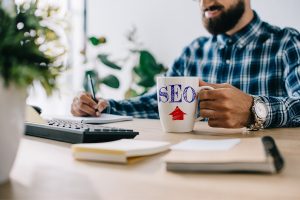 Barbat lucrand la laptop pentru a face optimizare SEO