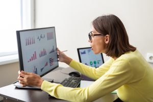 Femeie care analizeaza grafice cu metrice din Google Analytics 4